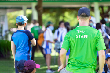 Team staff who standing  to watch document amid the children. Rear view.