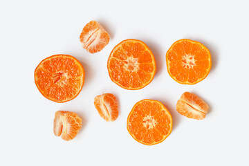 Top view of halves and slices of tangerine fruits isolated on light background. Citrus reticulata, mandarin orange, clementine