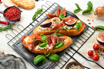 Bruschetta with prosciutto, figs and feta cheese. Antipasto. Top view.