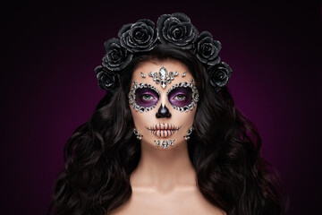Portrait of a woman with sugar skull makeup over red background. Halloween costume and make-up....
