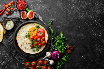 Omelet with tomatoes and parsley in a pan. Food for breakfast. Free space for your text. Top view.