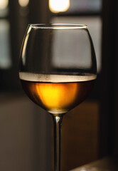 A glass of wine. Orange color. A big wine glass