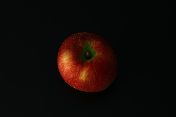 A Polish red apple on a black background
