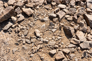 Surface covered with big stones on the ground. The surface of the hiking trail. Top view