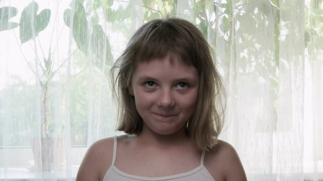 Little eight-year-old caucasian girl grimaces in front of camera. Mind blown reaction of little girl expressing her shock of something unbelievable. excited girl showing gesture of brain explosion
