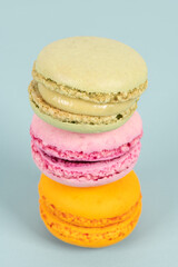 Cake macaron or macaroon on turquoise background from above, colorful almond cookies, pastel colors, vintage card