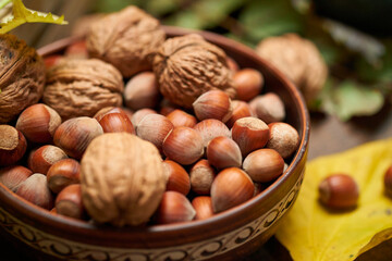 autumn still life in rustic style as a background - leaves, vegetables and fruits, nuts and other natural food ingredients on wooden boards
