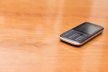 Obsolete dusty push-button phone on the table.