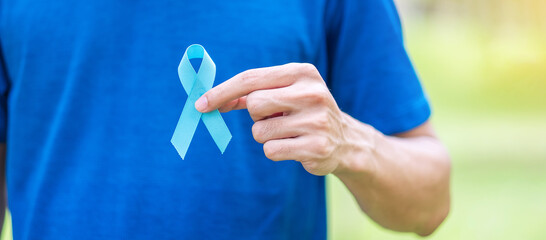 November Prostate Cancer Awareness month, Man in blue T shirt with hand holding Blue Ribbon for...
