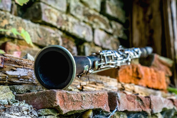 Music concept. Old clarinet on a background of a beautiful old broken brick wall.