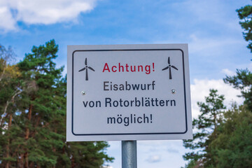 ein Warnschild vor Eisabwurf bei Windrädern