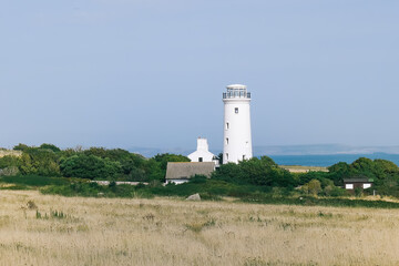 Fototapeta na wymiar A white lighthouse on the seaside