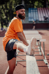 Healthy lifestyle. Handsome caucasian male athlete with long beard doing doing stretching exercise with copy space for your text © San4ezz007