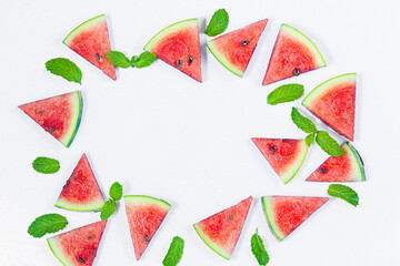 Creative summer food concept. Watermelon pattern. Juicy slices of ripe red watermelon and mint leaves on white background. Flat lay, top view, copy space. Summer berry, healthy nutrition, vitamins