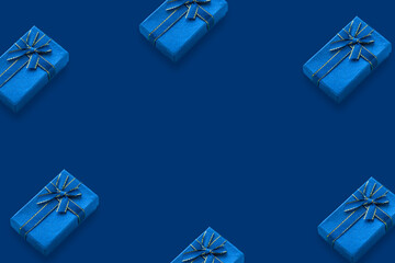 Pattern of gift boxes tied with a ribbon on a blue background with copy space