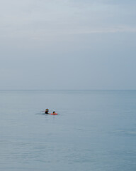 Family swimming in sea in the morning.