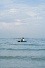 Fototapeta na wymiar Children standing on the floating raft water craft in the sea.