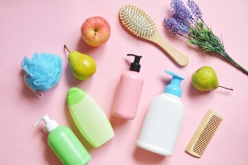 Flat lay beauty photography. Blue sponge, organic shampoo, hair conditioner, liquid soap and natural shower gel on a pink background