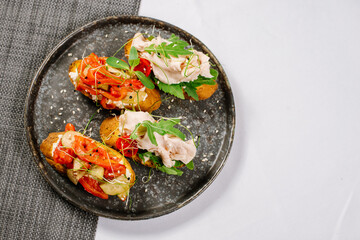 Tasty snacks with toasts, chicken meat and vegetables