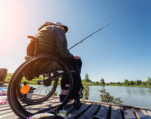 Young disabled man in a wheelchair fishing.