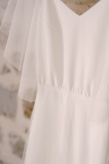 Close-up of the fabric of the bride's white wedding dress.