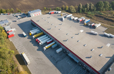 trucks drive up to the warehouse to unload and load goods
