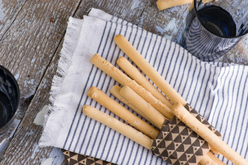 Italian bread sticks in a glass on a table with salt