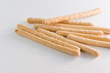 Italian bread sticks in a glass on a table with salt
