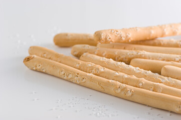 Italian bread sticks in a glass on a table with salt