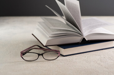 open book on the table, reading glasses