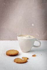 Latte or Cappuccino with frothy foam, coffee cup over rustic background