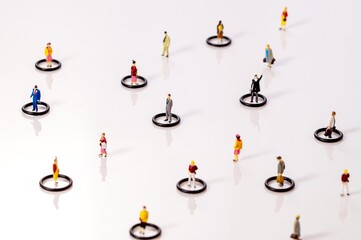 circle of miniature toy people in circles keeping distance in public. Social distancing due to the...