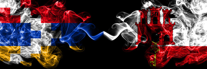 Nagorno-Karabakh, Artsakh vs Gibraltar smoky mystic flags placed side by side. Thick colored silky abstract smoke flags