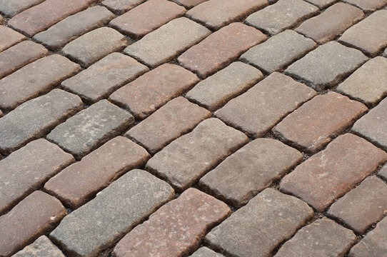 Abstract background of old cobblestone pavement close-up.