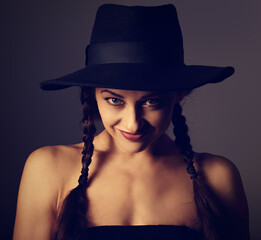 Beautiful fun positive young woman in style blue hat smiling on dark shadow background. Closeup portrait. Halloween kind concept. Toned