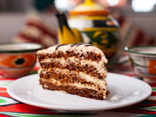  dessert chocolate cake with beige cream in oriental style on a rooftop with a teapot and a cup for tea.