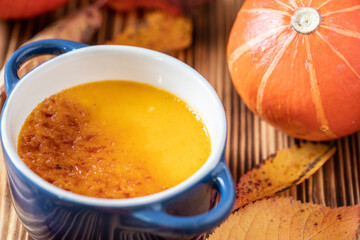 orange Creme Brulee aus Kürbis vom Hokkaido mit  karamellisierter Zuckerkruste in Förmchen auf...