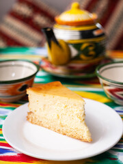 dessert chocolate cake with white butter cream in oriental style on a rooftop with a teapot and a cup for tea.