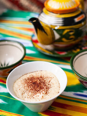  Tiramisu dessert in oriental style with a teapot and a cup for tea.