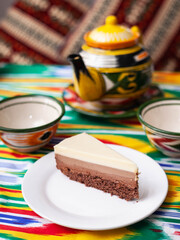  dessert cheesecake three chocolates in an oriental style with a teapot and a cup for tea.