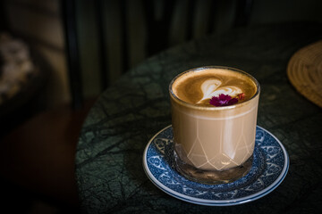 Latte in a glass with heart latte art inside. 
