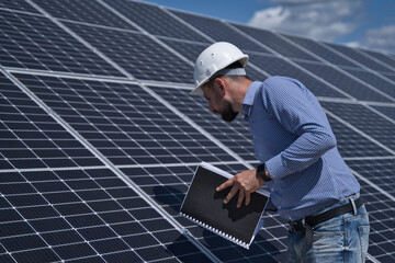 The engineer is checking the project of the solar station.