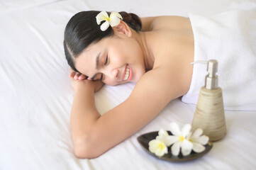A beautiful woman is relaxing and having massage in spa resort, Massage and beauty treatment concept.