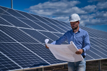 The engineer is checking the project of the solar station.