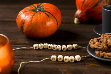 Happy Halloween text. Autumn concept with bright orange pumpkins on rustic wooden background. Happy...