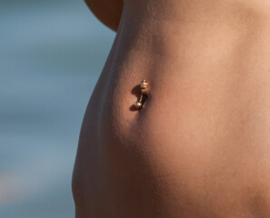 Fototapeta premium Belly button piercing of a girl in a bikini.