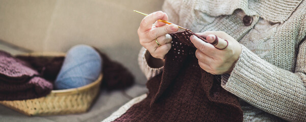 Asian old woman knitting crochet with taplet at home