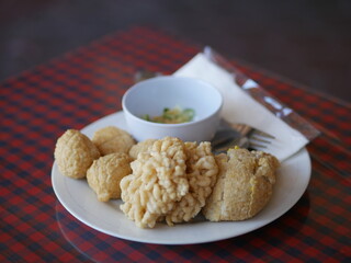 Indonesian Food empek-empek (savory fish cake dish) from Palembang, South Sumatra, Indonesia served in plate. Served in sweet and sour sauce with mashed ebi shrimp, dice cucumbers