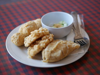 Indonesian Food empek-empek (savory fish cake dish) from Palembang, South Sumatra, Indonesia served in plate. Served in sweet and sour sauce with mashed ebi shrimp, dice cucumbers