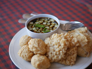 Indonesian Food empek-empek (savory fish cake dish) from Palembang, South Sumatra, Indonesia served in plate. Served in sweet and sour sauce with mashed ebi shrimp, dice cucumbers